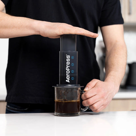 a man using AeroPress Original Coffee Maker to make cup of coffee