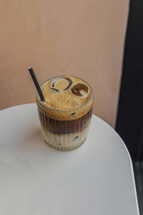 A Cup of ice coffee on a white table.