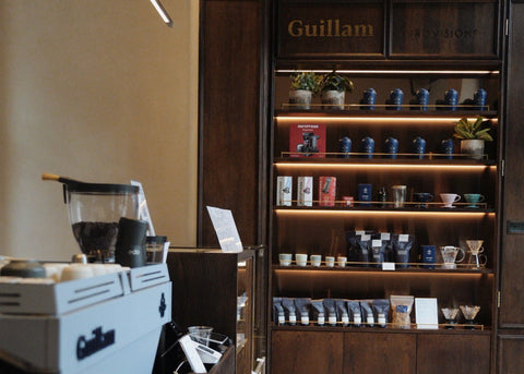 Shelf with coffee products and a coffee machine in a Guillam coffee house