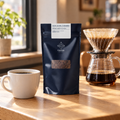 Jairo Arcila speciality coffee bag beside a pour-over and a cup in a café