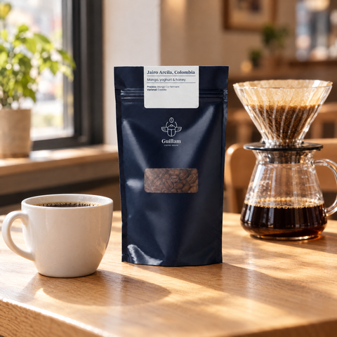 Jairo Arcila speciality coffee bag beside a pour-over and a cup in a café